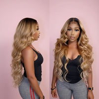 Woman with long blonde wavy hair wearing a black top and plaid pants.