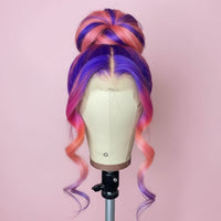 Multicolored wig on a mannequin head with a blurred indoor background